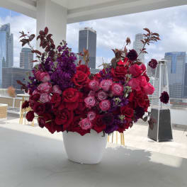 Large arrangement of red and pink roses in a white vase