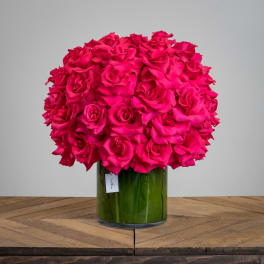 Bright pink rose bouquet in a green glass vase