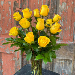 Yellow roses arranged in a clear glass vase