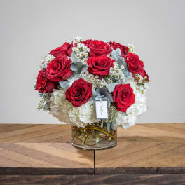 Red roses and white hydrangeas in a clear glass vase
