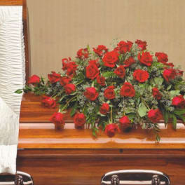 Red rose casket spray on a wooden casket