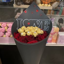 Black cone bouquet with red roses, gold chocolates, and an "I LOVE" topper