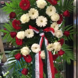 Tall standing floral spray with red and white flowers and ribbon streamers