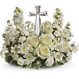 White floral arrangement with roses and a silver cross centerpiece