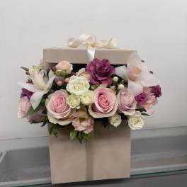 Pink and white roses with orchids in a beige gift box