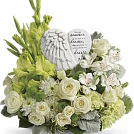 White floral sympathy arrangement with a heart-shaped memorial stone