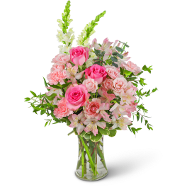 Pink roses and carnations in a clear glass vase