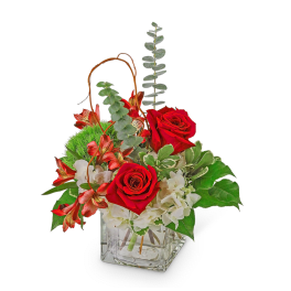 Red roses and white flowers in a square glass vase