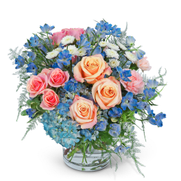 Pink and peach roses with blue and white flowers in a glass vase