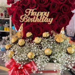 Red rose arrangement with a Happy Birthday topper and gold chocolates