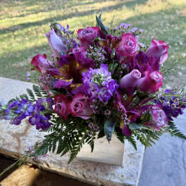 Pink and purple bouquet with roses and mixed blooms in a white box