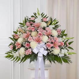 Large pink and white floral spray with a white ribbon bow