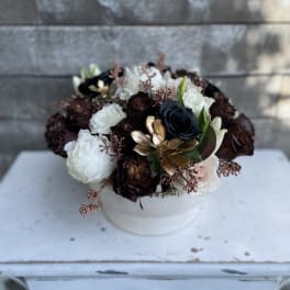 Round bouquet of white, blush, and dark roses in a white box