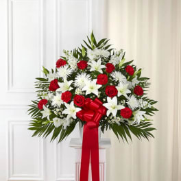 Large red and white floral spray with a red ribbon on a pedestal
