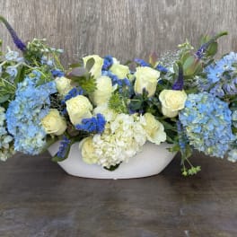 Blue and white floral arrangement in a white bowl vase