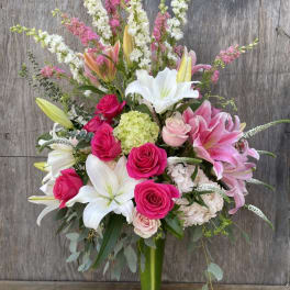 Tall bouquet of pink and white flowers in a glass vase