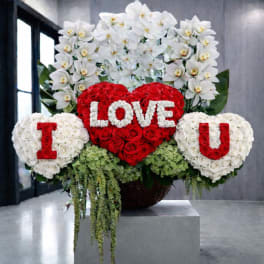 Heart-shaped rose arrangement with white orchid sprays and floral letters