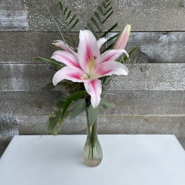 Pink lily arrangement in a clear glass vase