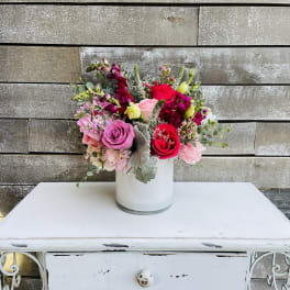 Mixed pink and red flower bouquet in a white vase
