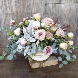 Blush roses and buds arranged in a white bowl vase