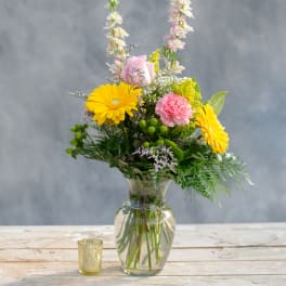 Mixed bouquet in a glass vase with yellow daisies and pink flowers