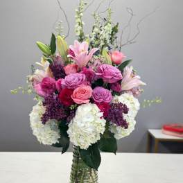Pink and white mixed flower arrangement in a glass vase