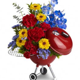 Red grill-shaped planter filled with colorful flowers