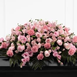 Pink floral casket spray with roses and carnations