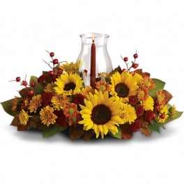 Sunflower and autumn floral centerpiece with a glass hurricane candle holder