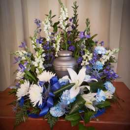 Funeral urn surrounded by blue and white flowers