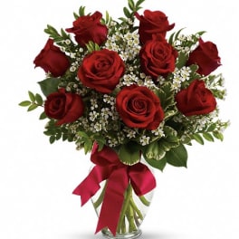 Bouquet of red roses with white filler flowers in a glass vase