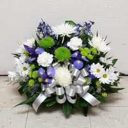 White and purple floral arrangement with a silver ribbon bow