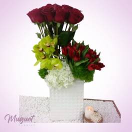 Tall floral arrangement with red roses, green orchids, and white hydrangea in a white vase