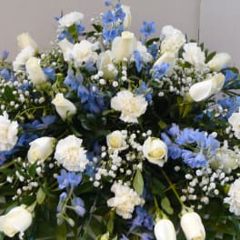 Large white and blue floral arrangement with roses and carnations
