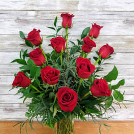 Red roses arranged in a clear glass vase