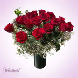 Red roses arranged in a black vase with baby's breath