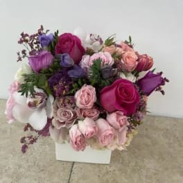 Mixed pink, purple, and white bouquet in a white box
