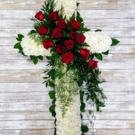 Cross-shaped floral arrangement with red roses and white blooms