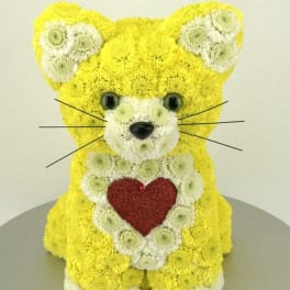 Yellow and white flower arrangement shaped like a teddy bear with a red heart