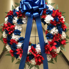 Red, white, and blue floral wreath with a large blue bow