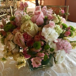 Pink and white mixed flower arrangement in a square glass vase