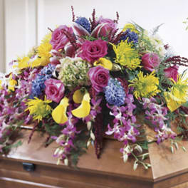Colorful floral casket spray with roses and orchids