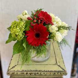 Red gerbera daisies and white roses in a glass vase