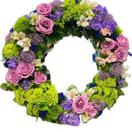 Circular floral wreath with pink roses, purple blooms, and bright green flowers
