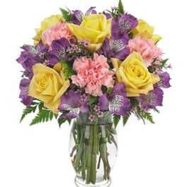 Yellow roses and purple flowers in a glass vase
