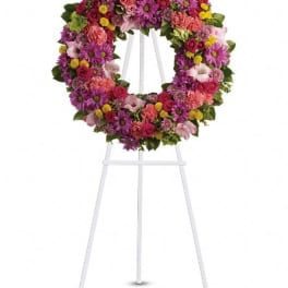 Colorful floral wreath on a white easel stand