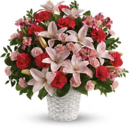 Pink lilies and red carnations in a white basket vase