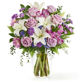 Bouquet of pink roses and white lilies in a clear glass vase