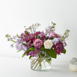 Mixed pink and lavender flowers in a clear glass vase