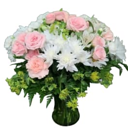 Pink roses and white daisies in a green glass vase
